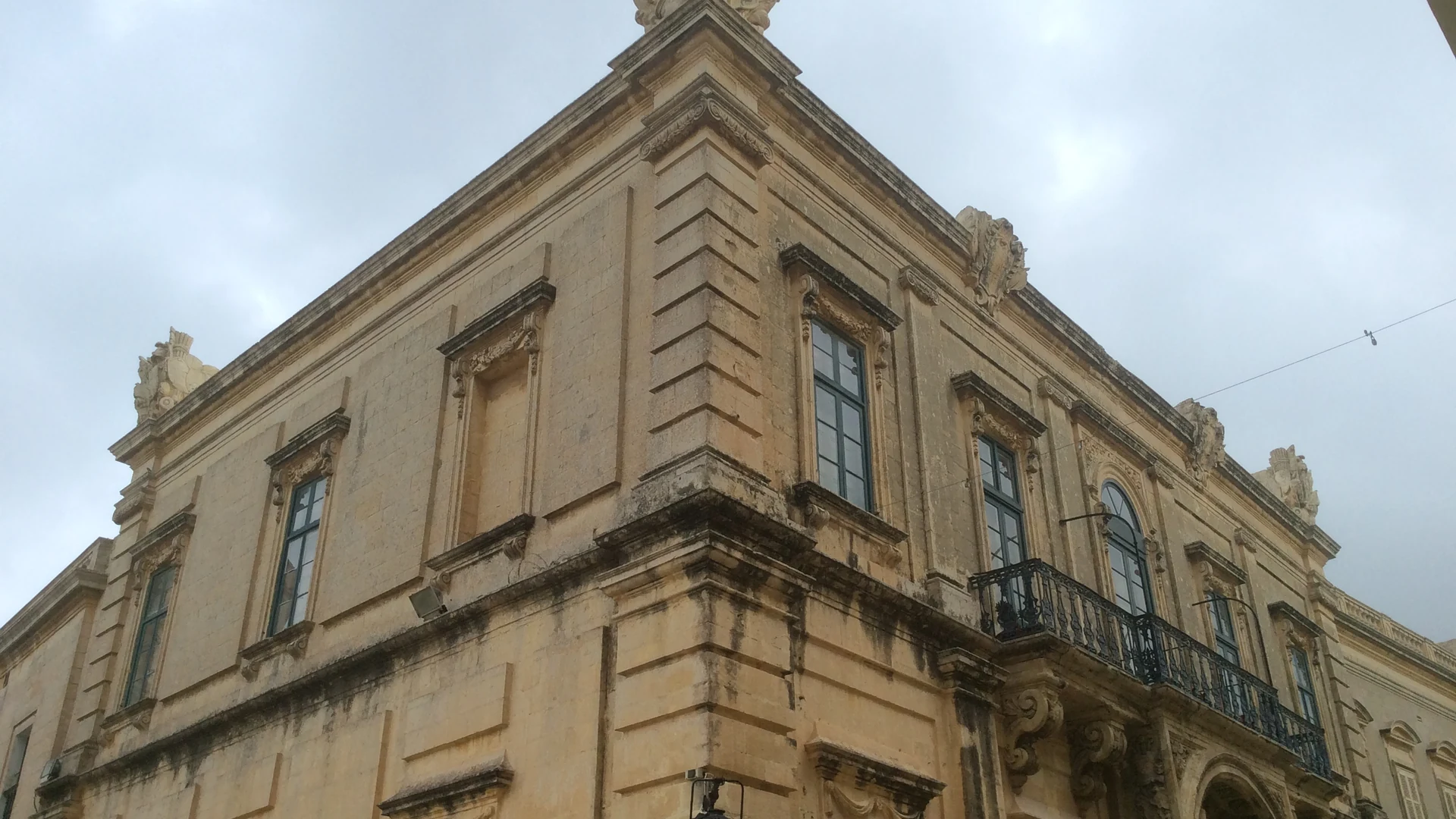 A honey-coloured Baroque palazzo facade in Malta, typical of the islands' heritage boutique buildings