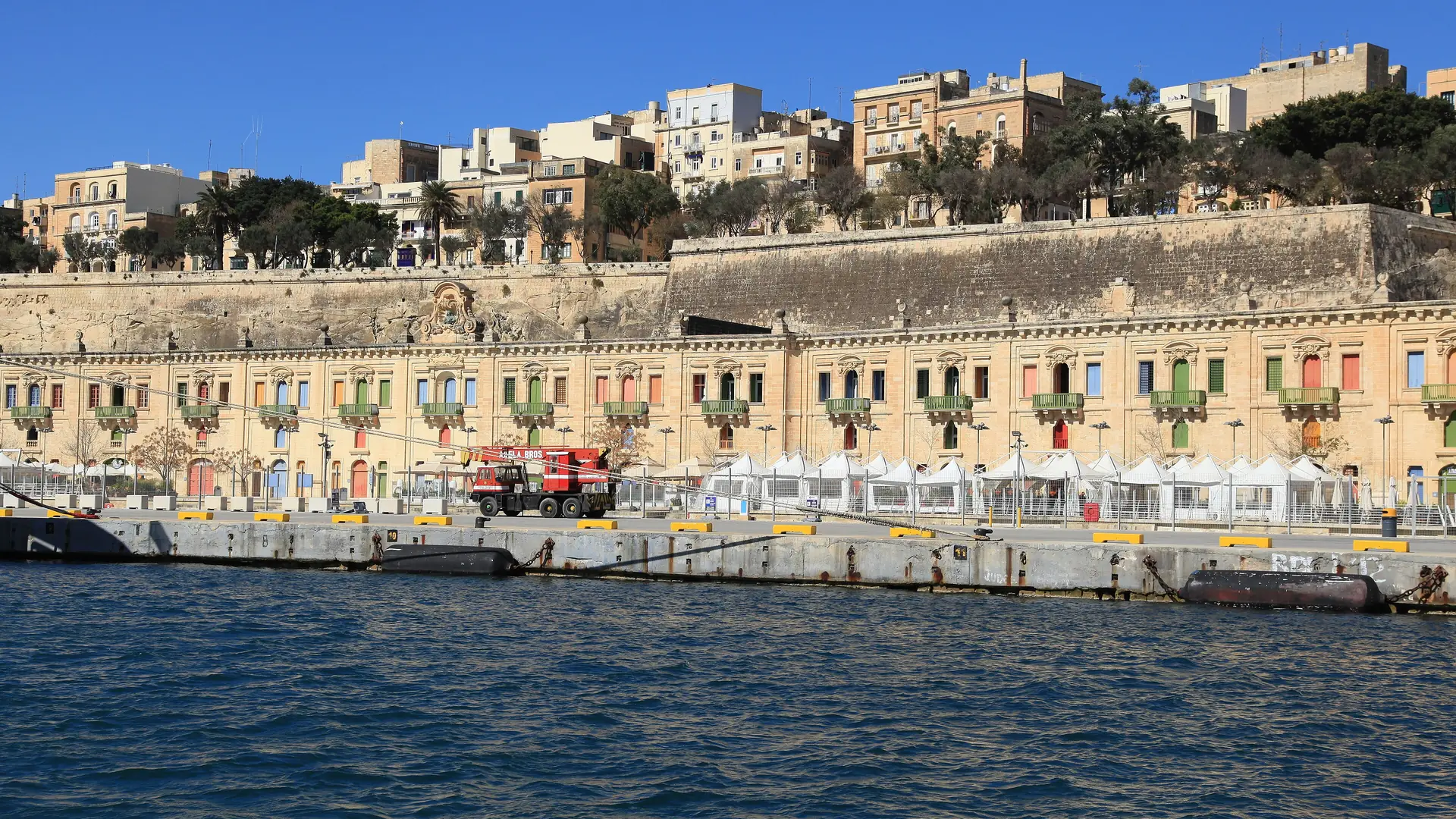 The Valletta Waterfront at Floriana with the cruise terminal, colourful restored buildings and a clear blue sky
