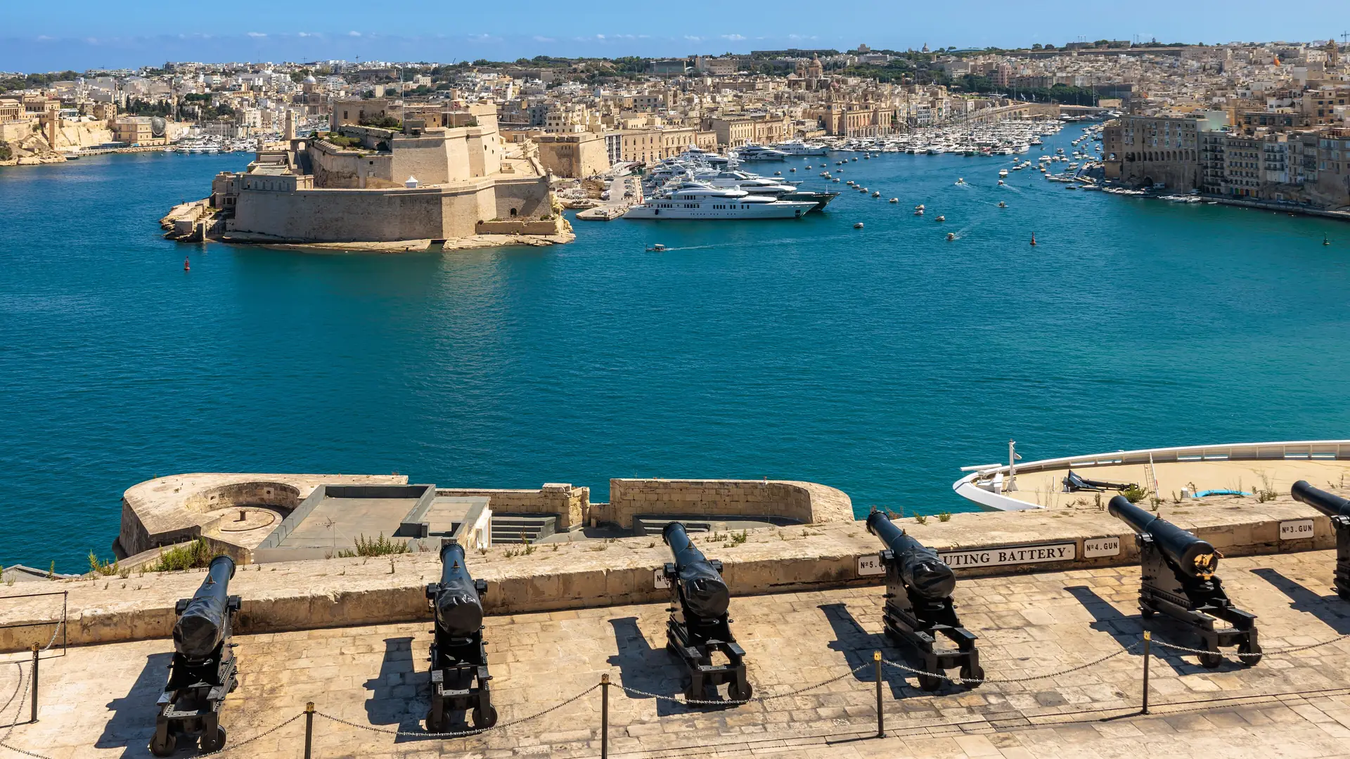 Valletta and its Grand Harbour seen from across the water under a clear blue sky