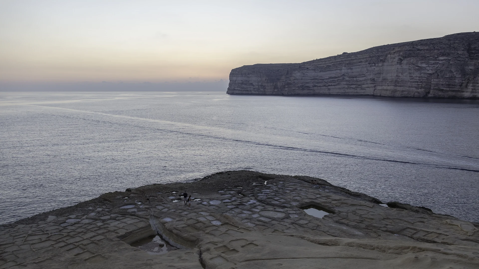 The calm, cliff-backed waters of Xlendi Bay on Gozo at dusk – the quiet end of a Maltese pool stay