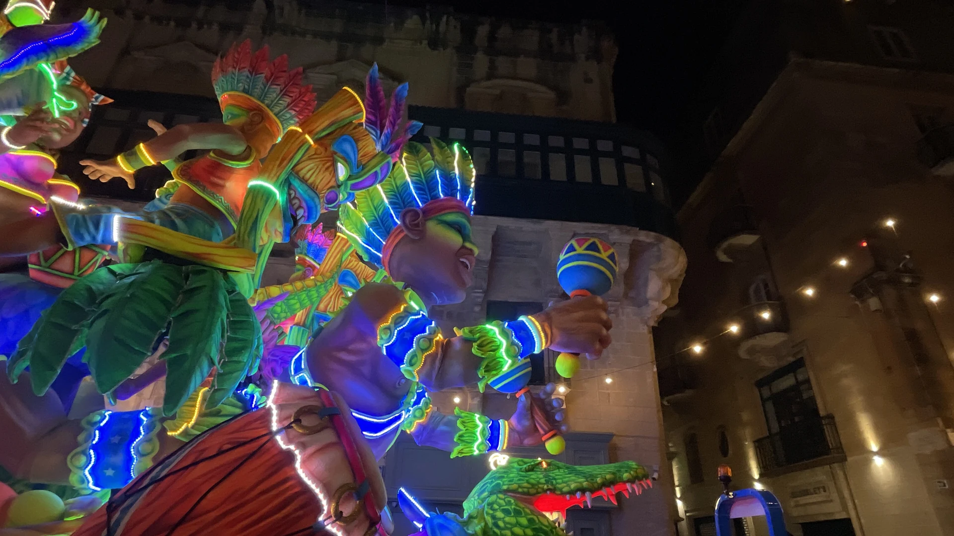 An illuminated Carnival float with colourful figures at night in Valletta, Malta