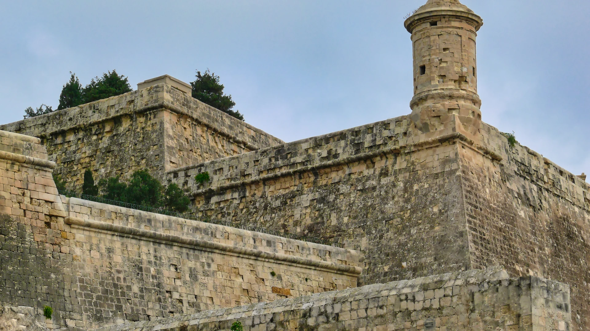 A bastion and watchtower of Valletta's fortifications under a soft, overcast sky, Malta