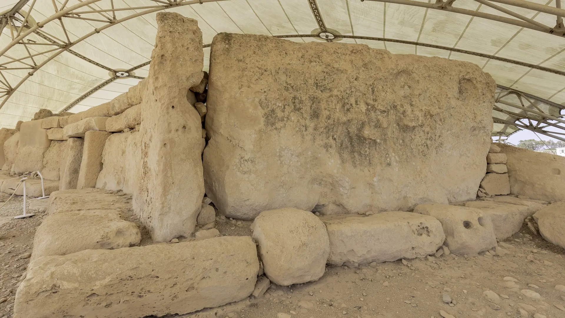 The massive limestone blocks of the Ħaġar Qim temple under its protective canopy in southern Malta
