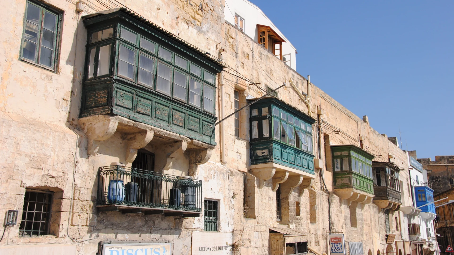 Traditional enclosed wooden balconies on a residential street in Malta