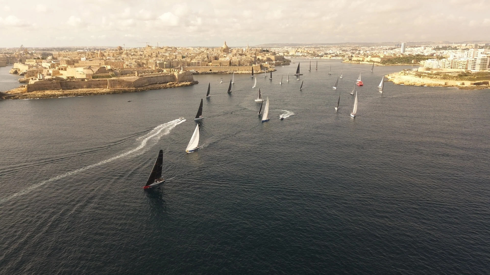 Sailing yachts on the blue water off Valletta's fortifications, Malta