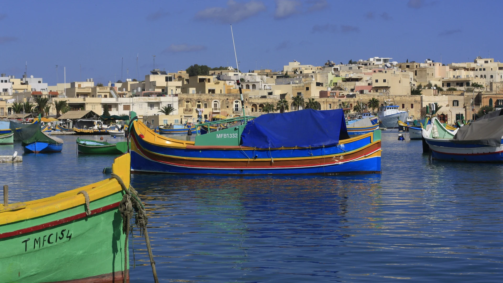 A brightly painted traditional luzzu fishing boat in Marsaxlokk harbour, Malta