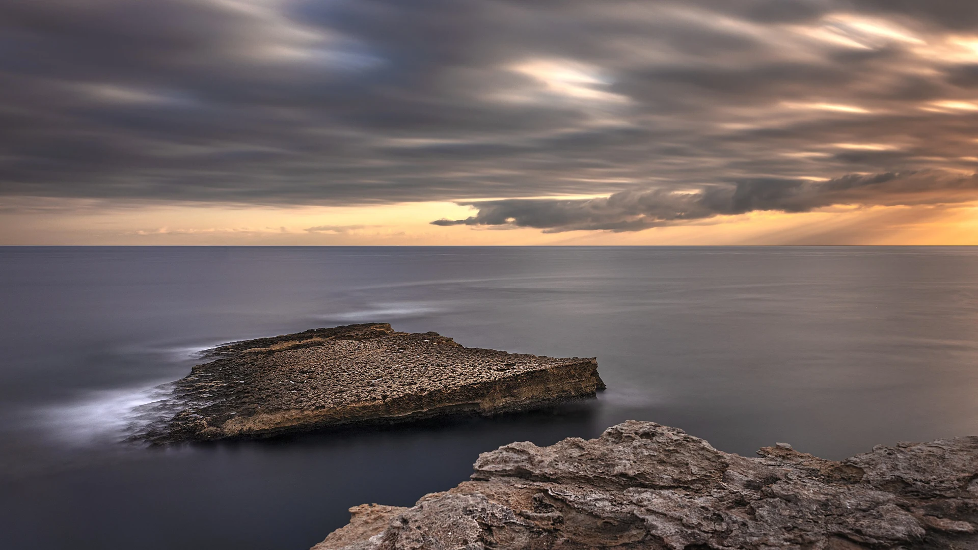 The jagged limestone cliffs and clear blue-green water of the Delimara coast in southeast Malta
