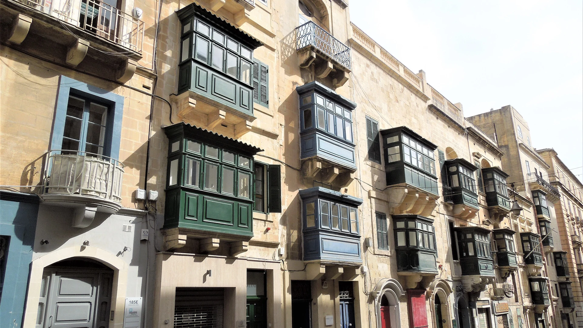 A narrow Valletta street lined with traditional enclosed timber balconies